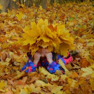забавная девочка в венке из кленовых листьев
