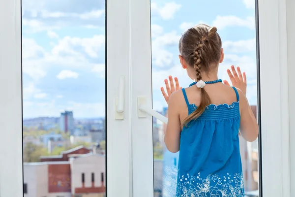 Ребенок, глядя через окно — стоковое фото