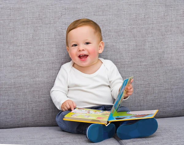 Один летний малыш сидит с книгой — стоковое фото
