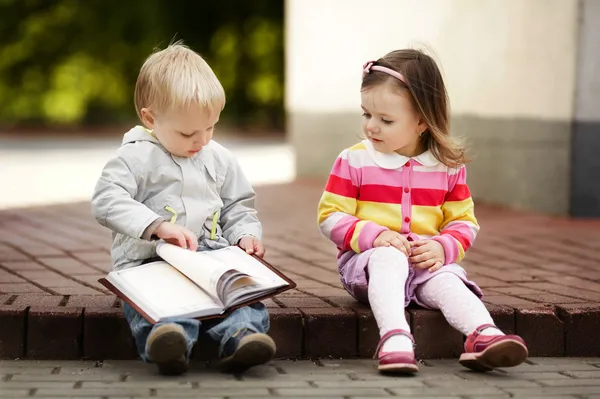 Мальчик и девочка чтение книги — стоковое фото