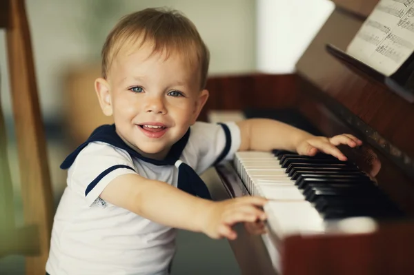 Маленький мальчик играет на пианино — стоковое фото