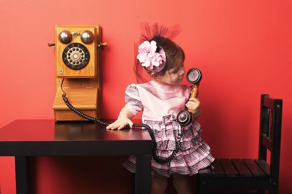 Маленькая девочка с ретро телефон — стоковое фото