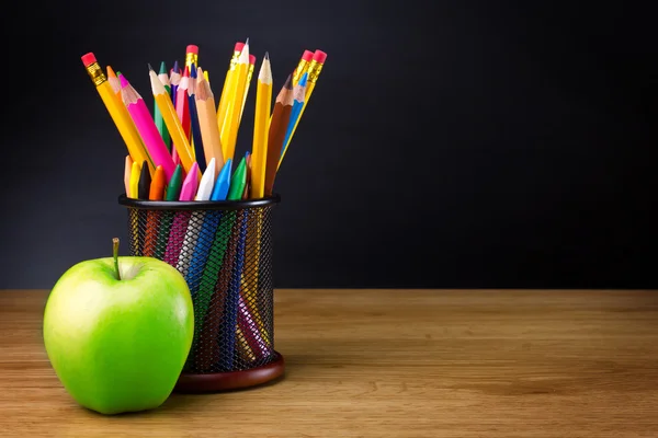 Apple на столе и карандаши — стоковое фото