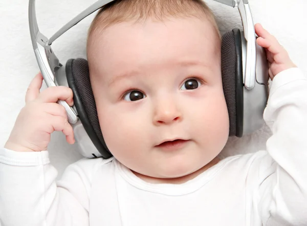 Ребенок прослушивания музыки на спине — стоковое фото