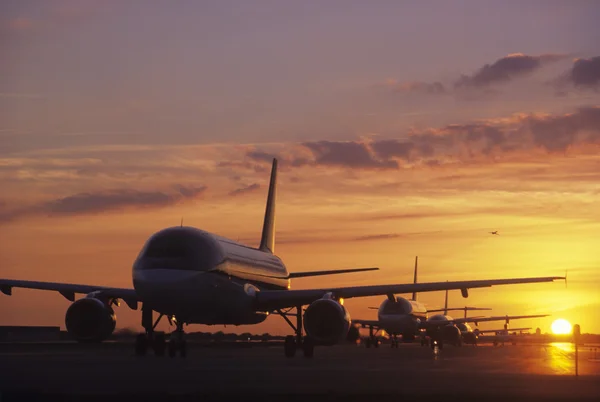 Самолеты, сидя на асфальте на закате — стоковое фото