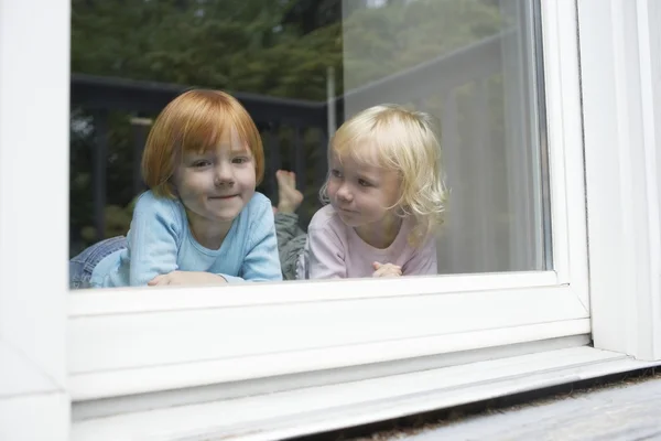 Маленькие сестры в окне — стоков