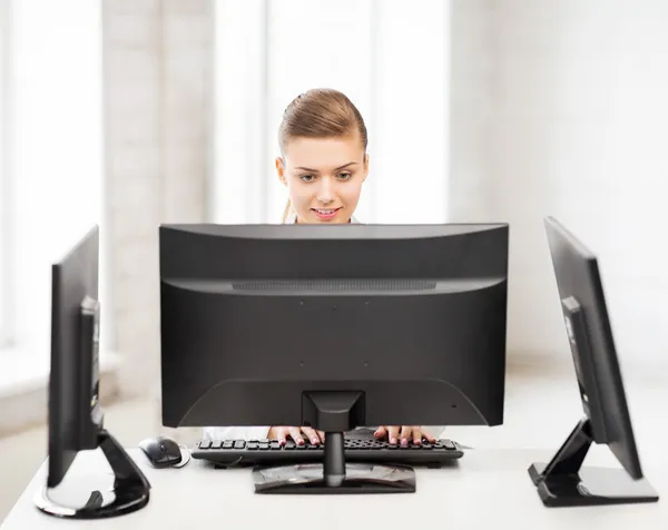 Бизнес-леди с компьютером и мониторы в офисе — стоковое фото
