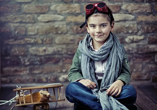 Мило улыбаясь мальчик с деревянный самолет — стоковое фото