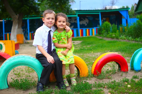 Мальчик и девочка дети, сидя на открытом воздухе во дворе успешно — стоковое фото