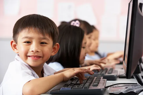 Мужской ученика с помощью клавиатуры во время компьютерного класса в китайских СКУ — стоковое фото