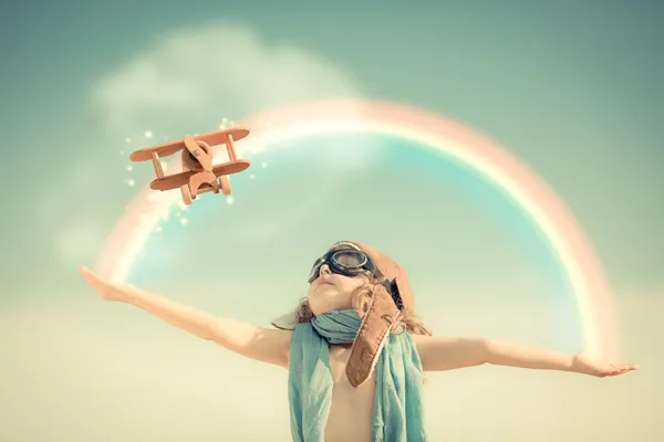 Счастливый ребенок, играющий с игрушечным самолетом — стоковое фото