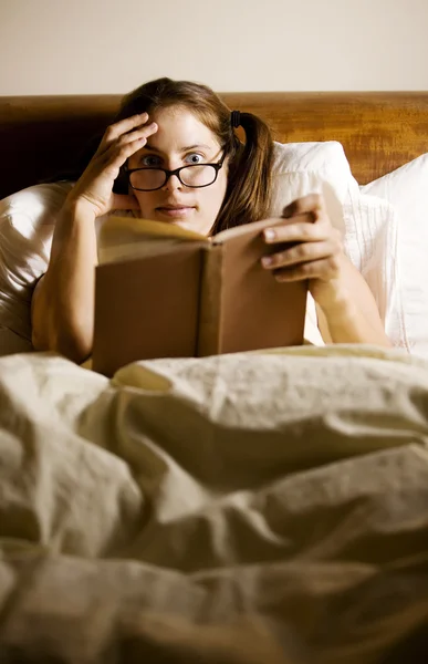 Женщина, читающая в постели — стоковое фото