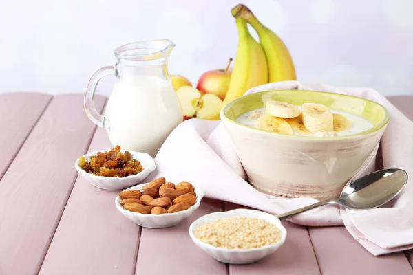 Вкусная овсяная каша с бананы и молоко на стол на светлом фоне — стоковое фото