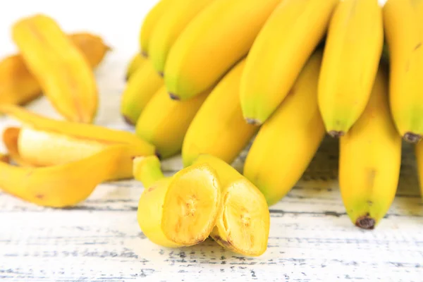 Куча мини-бананы на цвет фона и деревянные — стоковое фото