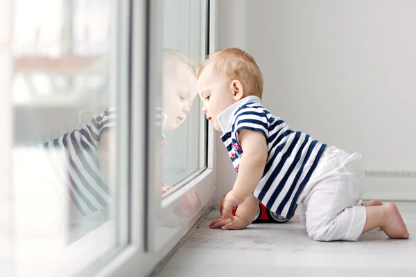 Маленький мальчик, глядя в окно — стоковое фото
