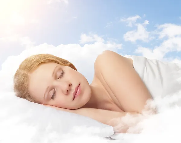 Красивая молодая женщина, спать на облако в небе — стоковое фото