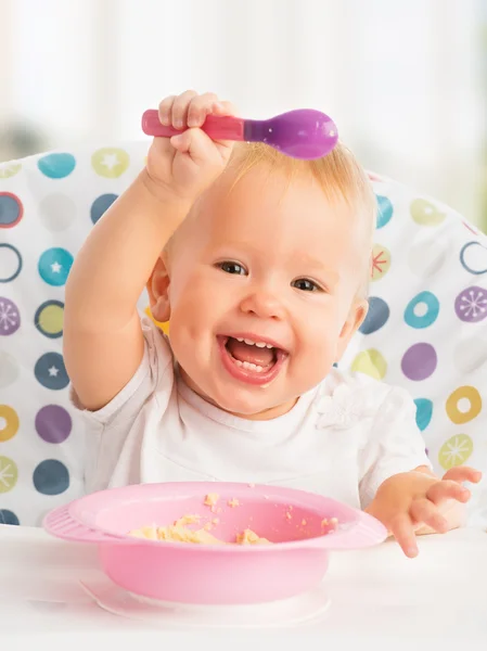 Счастливый малыш ребенок ест сам с ложкой — стоковое фото