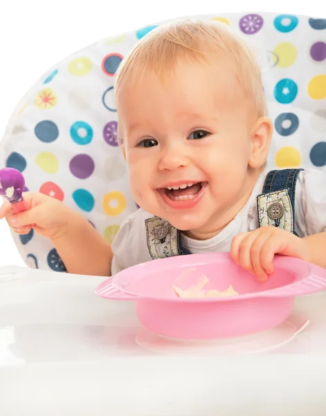 Счастливый малыш ребенок ест сам с ложкой — стоковое фото