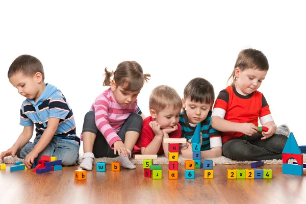 Пять детей, играющих на полу — стоковое фото