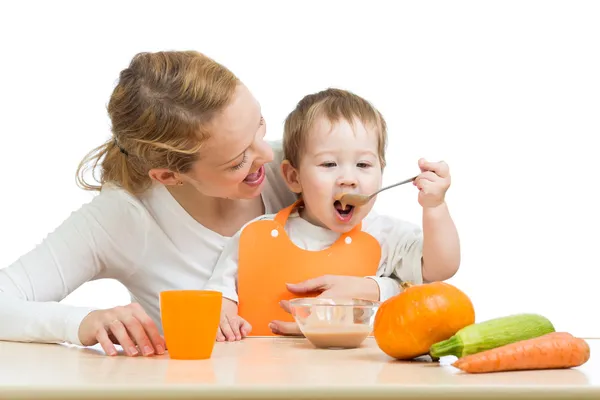 Ребенок, едящий овощи, протирает ложкой сам и сидящий на остроте — стоковое фото