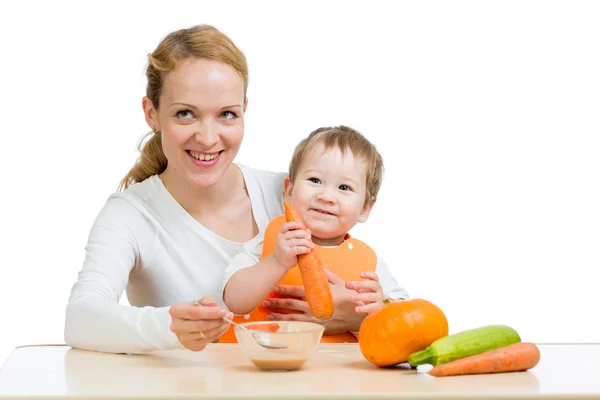 Мать ложкой кормить ребенка. Мальчик ест морковное пюре — стоковое фото