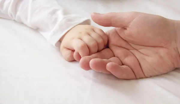 Крошечные руки сына и большая рука папа — стоковое фото