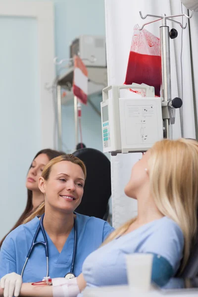 Улыбается медсестра, глядя на пациентки — стоковое фото