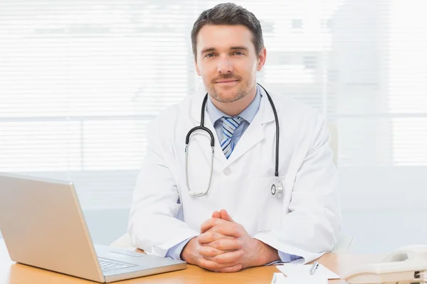 Мужской доктор с ноутбуком на стойке в медицинском кабинете — стоковое фото