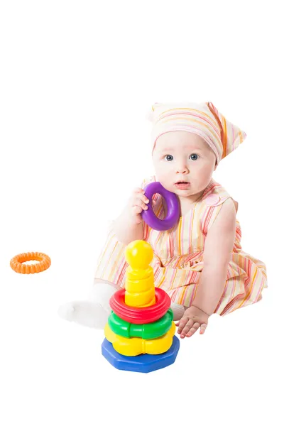 Девочка, играющая с игрушечной пирамидой, строит из колец, изолированных на белом background.toy для детей и малышей, чтобы радостно освоить механические навыки и цвета — стоковое фото