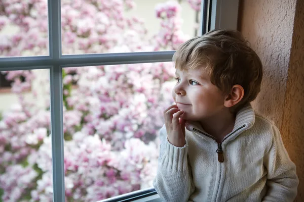 Очаровательны малыш мальчик смотрит в окно — стоковое фото