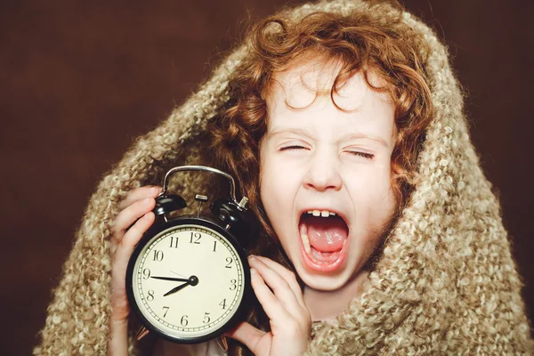Кудрявая девушка зевать и проведение будильник. Фото тонированный коричневый — стоковое фото