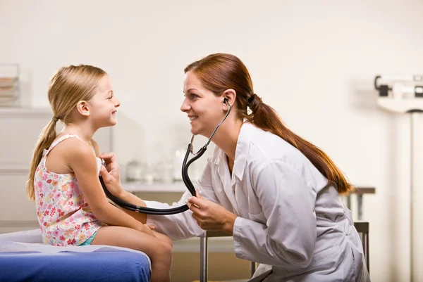 Доктор, осматривающий маленькую девочку — стоковое фото