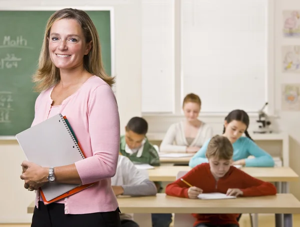 Учитель, стоя с ноутбука в классе — стоковое фото
