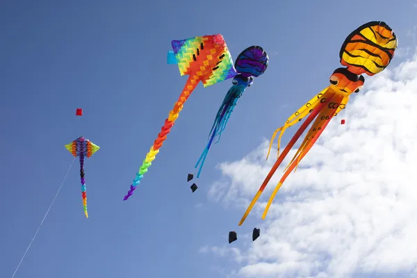 Красочные летающие бумажные змеи против синего неба — стоковое фото