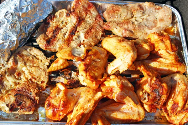 Колбаса, крылья и шейку свинины на grilu — стоковое фото