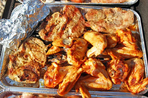 Колбаса, крылья и шейку свинины на grilu — стоковое фото