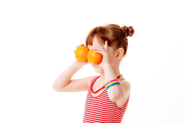 Девочка закрывает глаза с апельсинами — стоковое фото