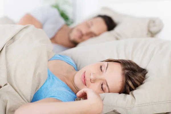 Молодая пара, спящая в постели — стоковое фото