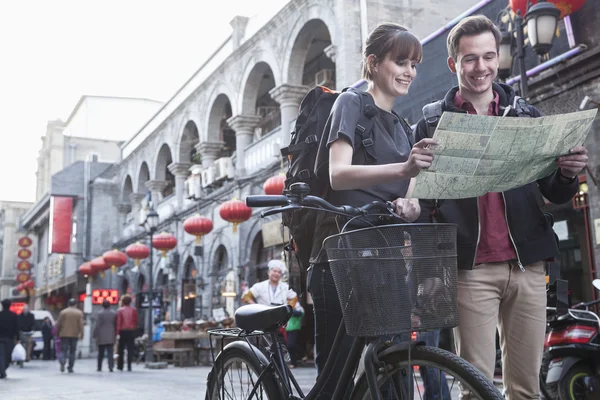 Мужчина и женщина с велосипедов и карта — стоковое фото