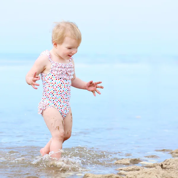 Счастливый малыш девочка, играя на пляже — стоковое фото