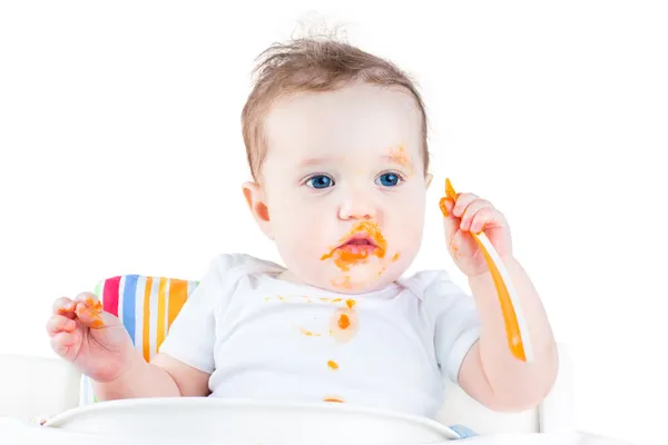 Ребенок ест ее первой твердой растительной пищей — стоковое фото