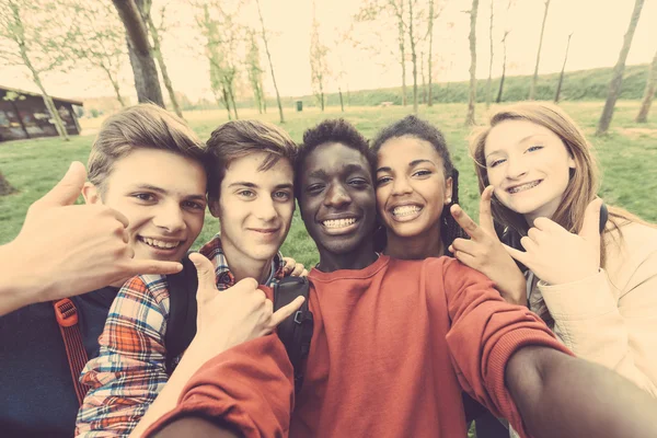Группа многоэтнических подростков, принимая selfie в парке — стоковое фото