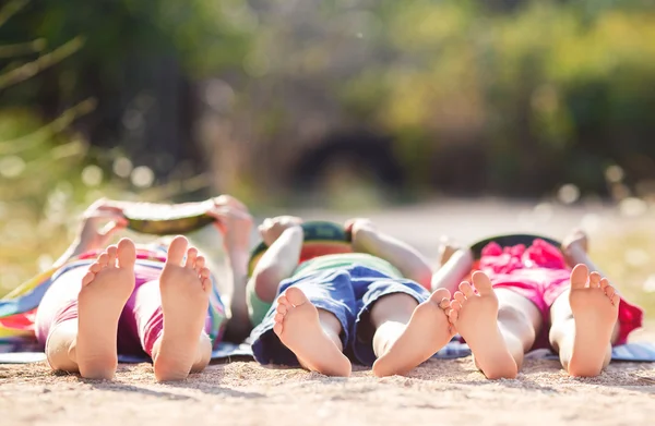 Дети лежат на земле в парке и едят арбуз — стоковое фото