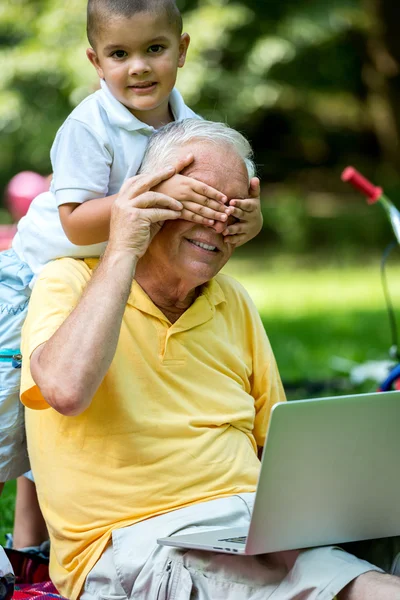 Дед и ребенка с использованием портативного компьютера — стоковое фото
