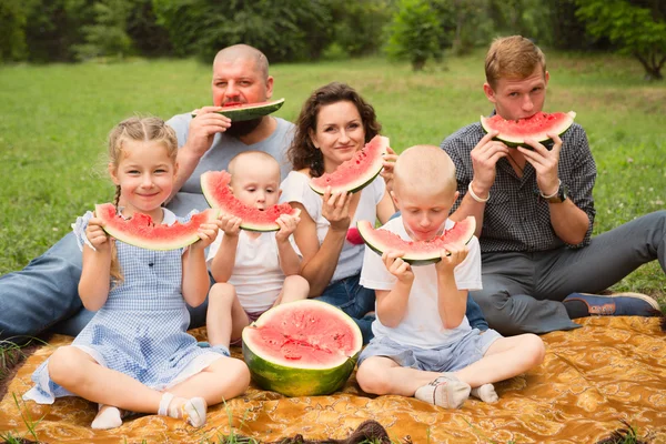 Родители с детьми, едят арбуз — стоковое фото