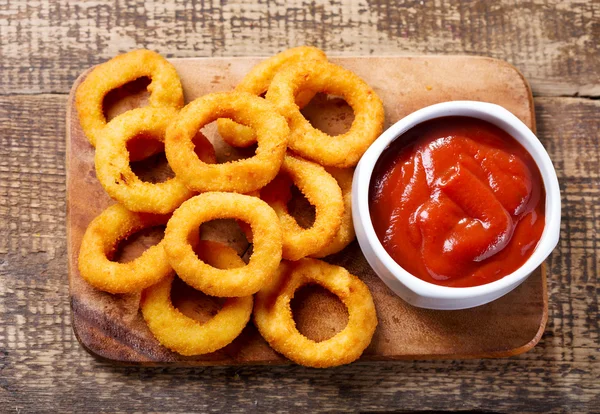 Луковые кольца с кетчупом — стоковое фото