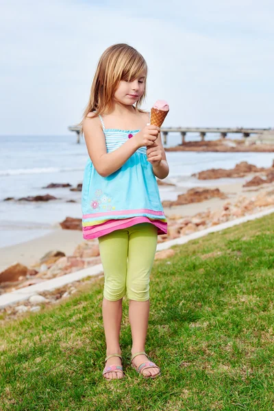 Девушка, наслаждаясь мороженым на пляже — стоковое фото
