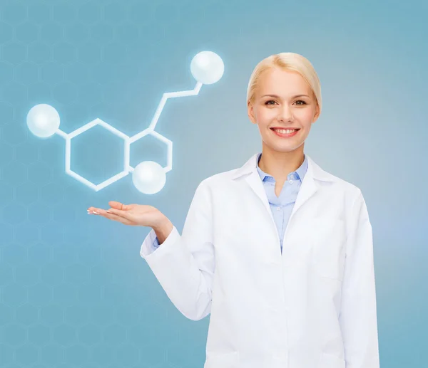 Улыбающаяся женщина-врач, указывающая на молекулу — стоковое фото