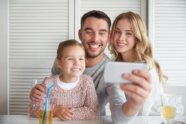 Счастливые семьи принимая selfie в ресторане — стоковое фото