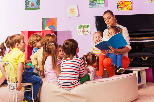 Медсестра в детском саду, читать книгу — стоковое фото